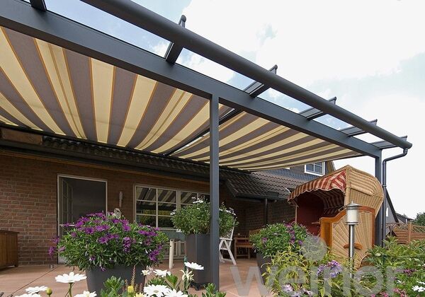 Moderne Terrassenüberdachung mit Markise und Gartenmöbeln auf einer gepflegten Terrasse.