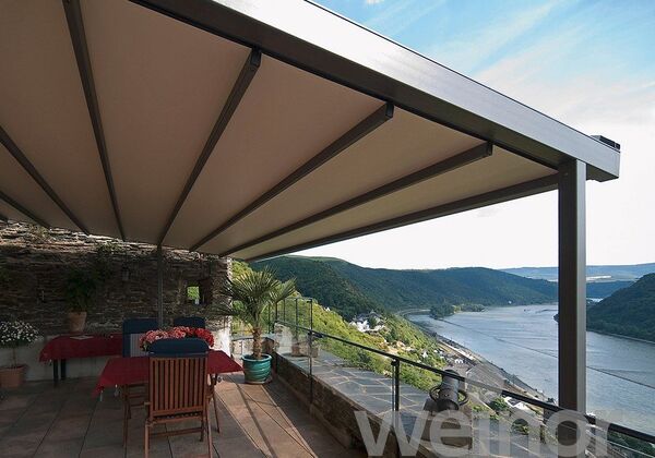 Überdachte Terrasse mit Markise und Blick auf Flusslandschaft im Sommer, Outdoor-Möbel